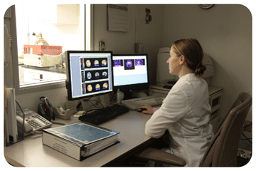 researcher at PET scanner control room console