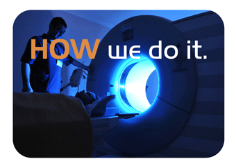 Research participant in darkened MRI scanner with investigator nearby