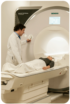 Researcher standing next to participant lying on scanner bed